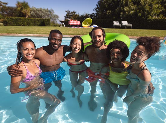 A group of diverse adults in a pool after Perfect Pool Steps repair.
